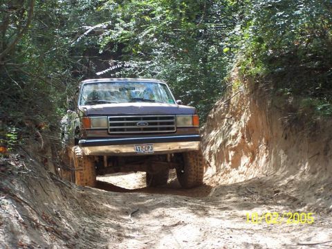 1987 Ford Bronco - Ford Bronco tackles an off-road trail on a sunny day.