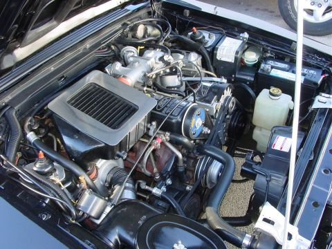 1986 Ford Mustang - Close-up of the engine bay, showing the turbocharger and intercooler system.