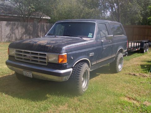 1989 Ford Bronco - This 1989 Ford Bronco is parked on a grassy lawn with a wooden fence in the background.