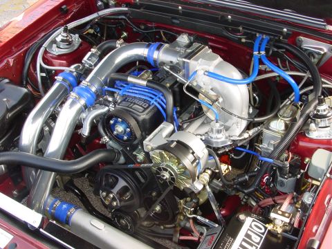 1986 Ford Mustang - Detailed view of a modified 1986 Ford Mustang engine bay, highlighting the turbocharger and custom plumbing.