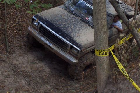 1987 Ford Bronco - This truck appears to be stuck in the mud, with caution tape wrapped around a nearby tree.
