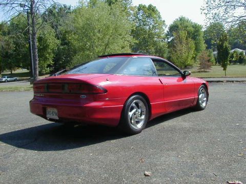1997 Ford Probe - A red 1997 Ford Probe is viewed from its rear-right quarter, parked outdoors on an asphalt surface.