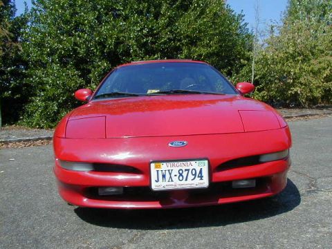 1997 Ford Probe - A red 1997 Ford Probe is shown from the front, parked outdoors with trees in the background.