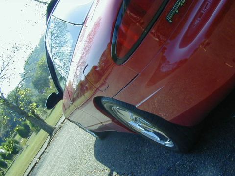 1997 Ford Probe - Rear quarter panel view of a red 1997 Ford Probe GT, showing the wheel and a portion of the body.