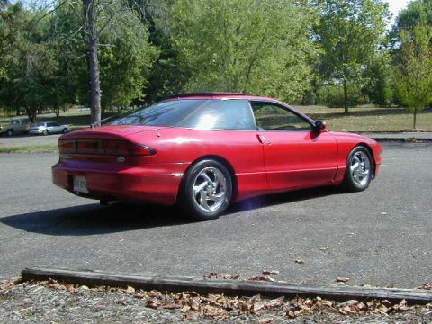 1997 Ford Probe - A red 1997 Ford Probe is shown from a three-quarter rear view on a paved surface.