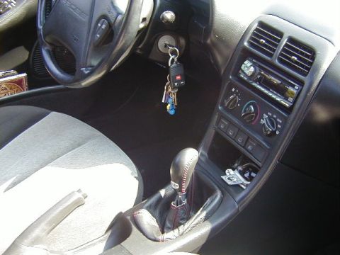 1997 Ford Probe - The interior of a 1997 Ford Probe shows an automatic transmission shifter and an aftermarket stereo system.