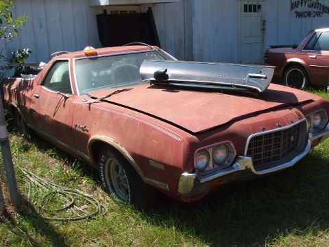 1966 Ford Ranchero - This 1970 Ford Ranchero is parked outside a building, with a fender resting on its hood.