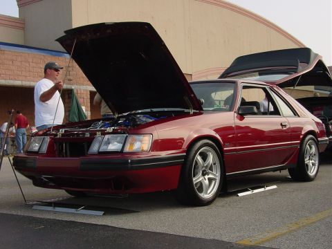 1986 Ford Mustang - A red 1987 Ford Mustang coupe is displayed with its hood and trunk open.