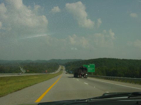 1986 Ford Mustang - Driving on a highway with a truck ahead and a green road sign.