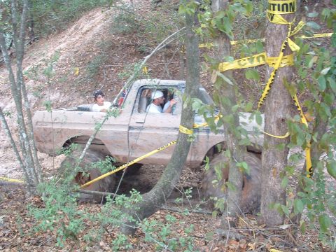 1993 Ford Bronco - A heavily modified pickup truck navigates a wooded, off-road course.
