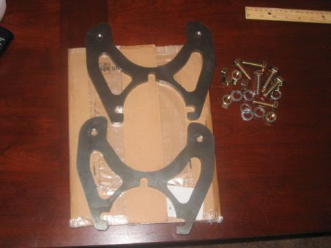 1991 Ford Bronco - Unidentified metal parts and fasteners are laid out on a wooden surface.