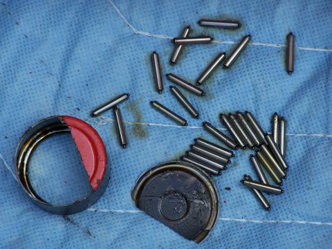 1979 Ford F-150 - Scattered roller bearings and pieces of a transmission housing are laid out on a blue cloth, suggesting internal mechanical components.