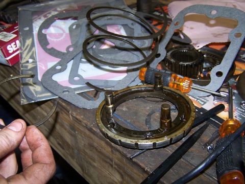 1979 Ford F-150 - Various transmission components and gasket sets are spread across a workbench, ready for assembly or repair.