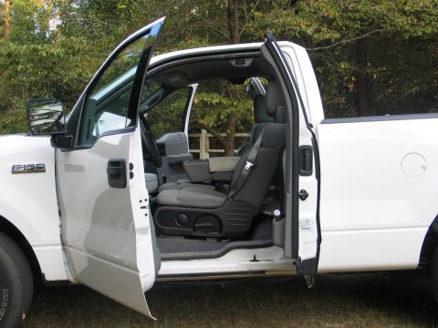 2004 Ford F-150 - Interior view of a white 2004 Ford F-150 pickup truck, with both front doors open.
