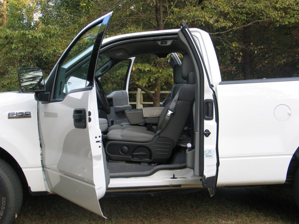 White 2004 Ford F-150 interior with doors open, showing front seats and dashboard