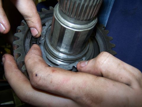1979 Ford F-150 - Close-up of hands working on a transmission part, likely a synchronizer ring and gear.