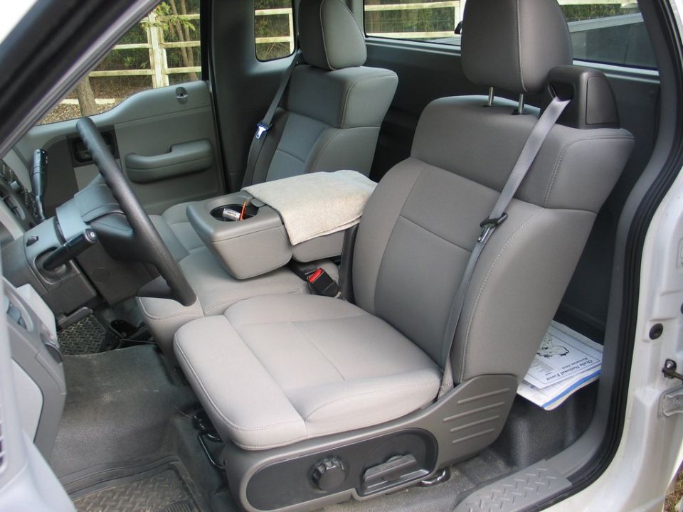 Gray cloth interior of a 2004 Ford F-150, showing front seats, dashboard, and steering wheel from the passenger side