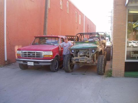 1992 Ford Bronco - Two vehicles, a red Ford pickup and a green Suzuki Samurai, are parked side-by-side.