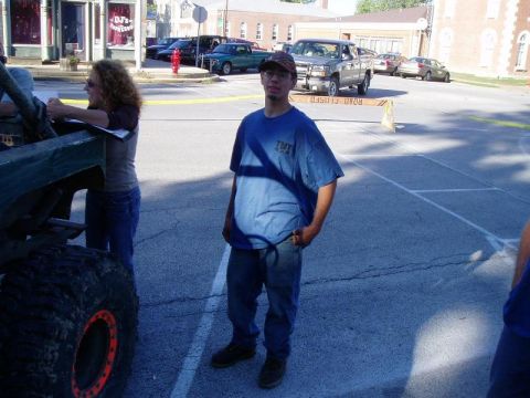 1992 Ford Bronco - A group of people stand around a large off-road vehicle in a parking lot with a road closed sign.