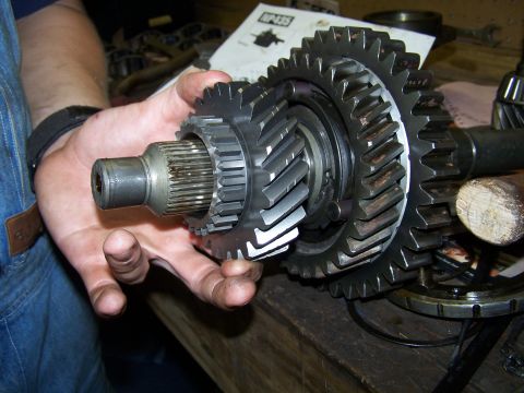 1979 Ford F-150 - Transmission gears are held up for inspection, with a diagram visible behind.