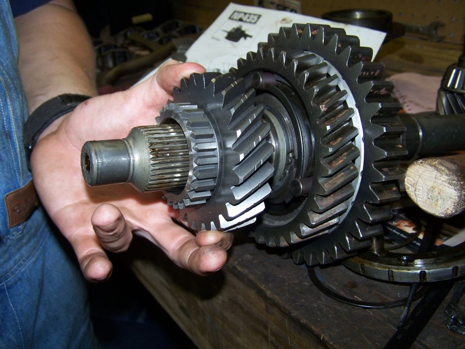 Close-up of transmission gears being held, with NP435 diagram in background