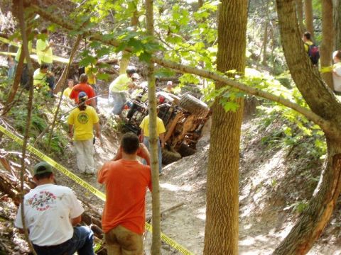 1992 Ford Bronco - An off-road vehicle is stuck in a ditch while onlookers observe the scene.