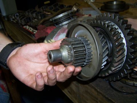 1979 Ford F-150 - Close-up of transmission gears being held by a hand, with other parts in the background.