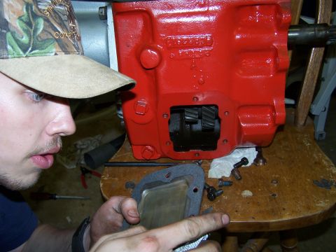 1979 Ford F-150 - A person works on a red transmission housing, revealing internal gears and casting numbers.