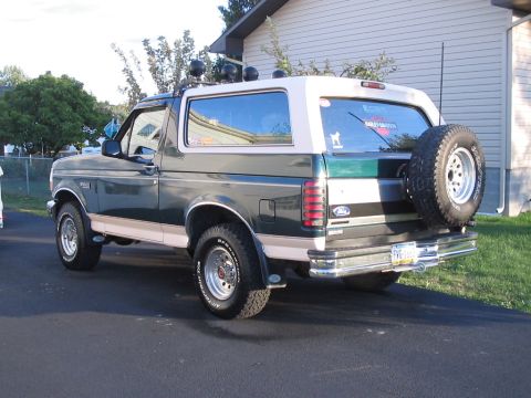 1992 Ford Bronco - The rear three-quarter view of a 1992 Ford Bronco shows its two-tone paint scheme and external spare tire.
