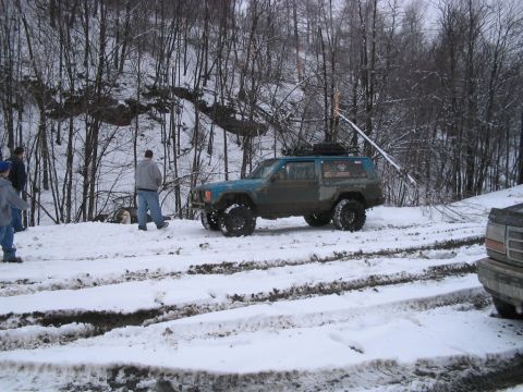 1992 Ford Bronco - Modified Jeep Cherokee navigates snowy terrain with other vehicles present.