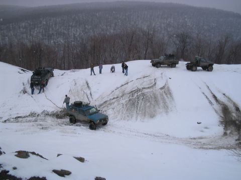 1992 Ford Bronco - Several off-road vehicles and people are engaged in activity on a snow-covered hill, with a watermark for Supermotors.net visible.