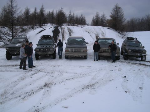 1992 Ford Bronco - Group of SUVs and trucks gathered in a snowy, wooded area.