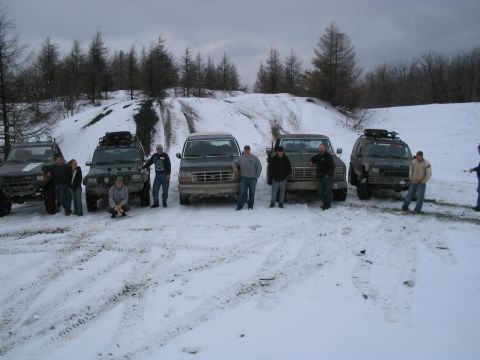 1992 Ford Bronco - A group of people and their off-road vehicles are gathered in a snowy, outdoor landscape.