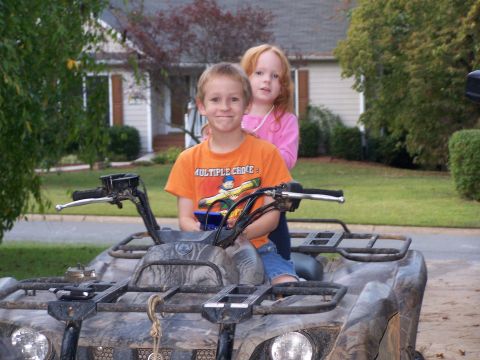1979 Ford F-150 - Two kids ride on a camouflage ATV in front of a house.