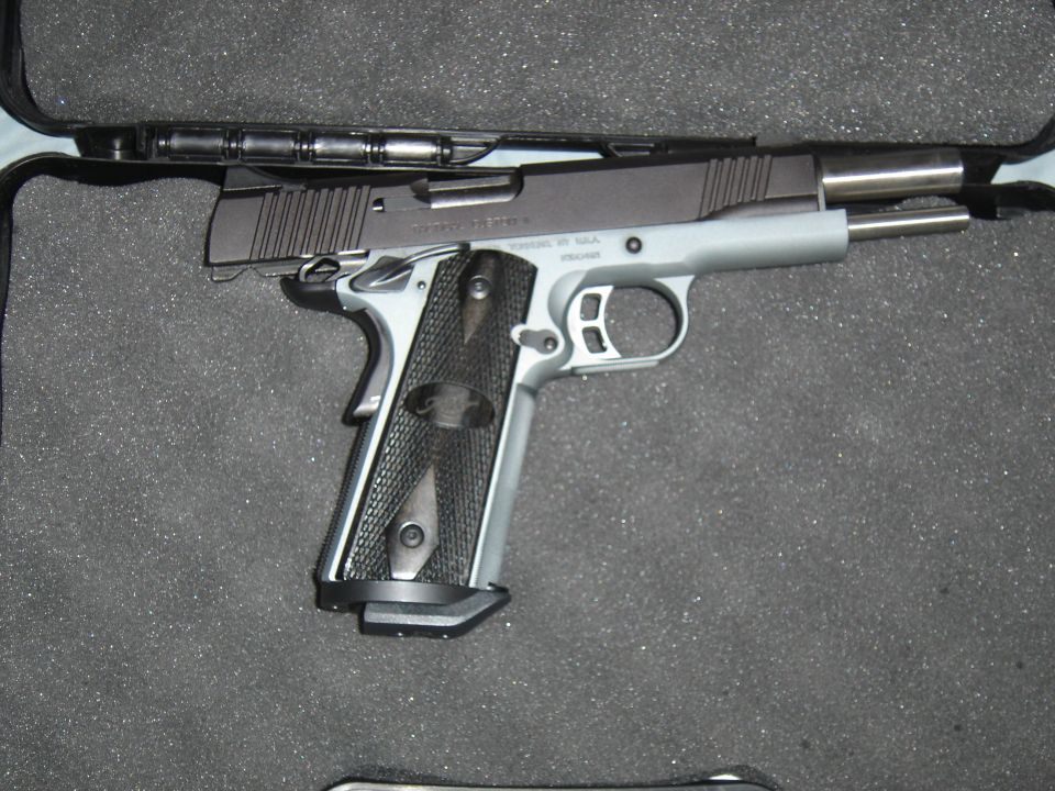 Silver and black semi-automatic handgun in a foam-lined case