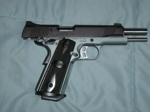 1988 Ford Bronco - Pistol with black slide and silver frame, textured grip panels, resting on a blue cloth.