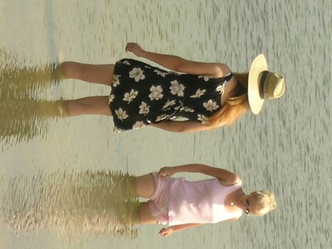 1993 Ford Probe - Reflections of two women in the water, one in a floral dress and the other in a pink top.
