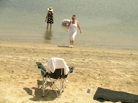 1993 Ford Probe - People enjoy a day at the beach, with a folding chair set up on the sand.