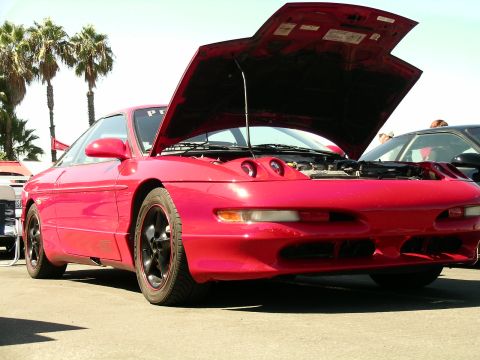 1993 Ford Probe - Front view of a red 1993 Ford Probe with its hood open, parked at an outdoor event.