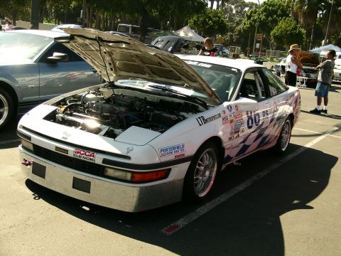 1993 Ford Probe - A white 1993 Ford Probe race car is parked with its hood open, revealing the engine bay and various racing decals.