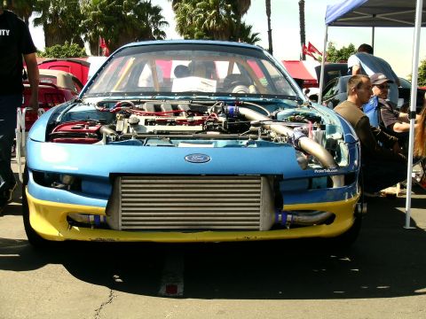 1993 Ford Probe - This modified car, possibly a Ford Probe, features an open hood revealing its engine and a large intercooler.