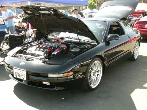 1993 Ford Probe - A black Ford Probe is displayed with its hood and trunk open, revealing the engine bay.