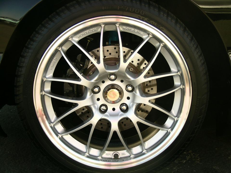 Silver multi-spoke alloy wheel with drilled brake rotor and tire