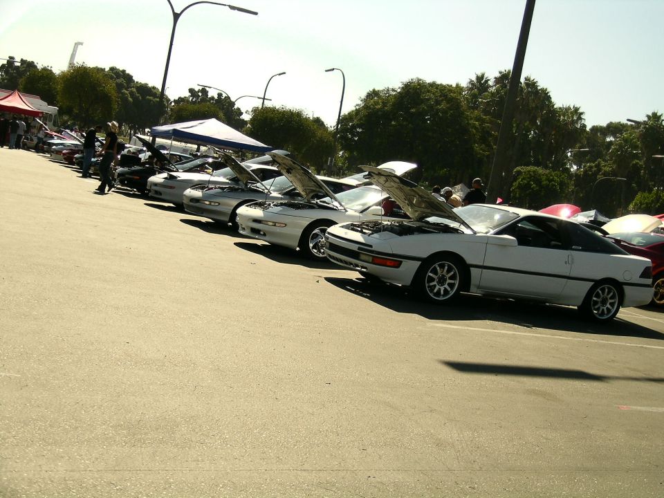 White 1993 Ford Probe with hood open, parked in a line with other cars