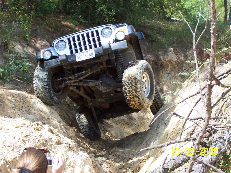 Silver Jeep Wrangler TJ navigating a steep dirt incline