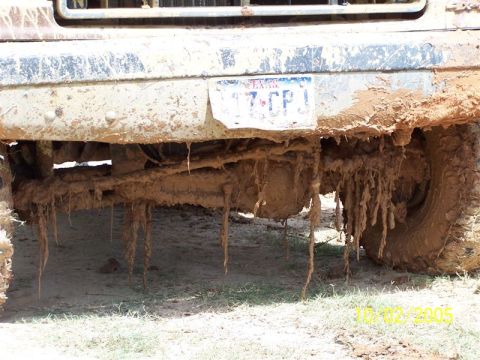 1987 Ford Bronco - Front underside of a mud-covered truck with dripping caked mud hanging off the chassis and a partly visible license plate, dated 10/02/2005.
