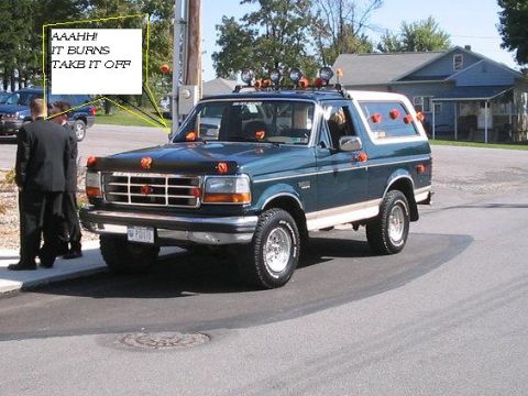 1986 Ford Bronco - A teal/green 1992-96 Ford Bronco with a two-tone lower body, chrome grille and wheels, a roof-mounted light bar with five off-road lights,…