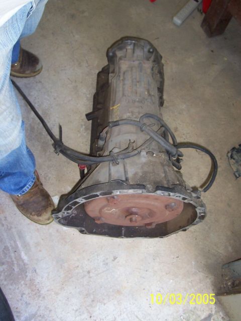 1994 Jeep YJ - An automatic transmission is shown on a concrete floor, with a person's legs visible to the left.