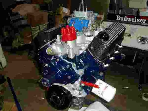 1969 Ford Bronco - A blue engine with a red distributor cap is shown, with a Budweiser logo visible in the background.