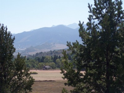 1972 Ford Ranchero - A wide view of mountains and trees frames a small building in a field.